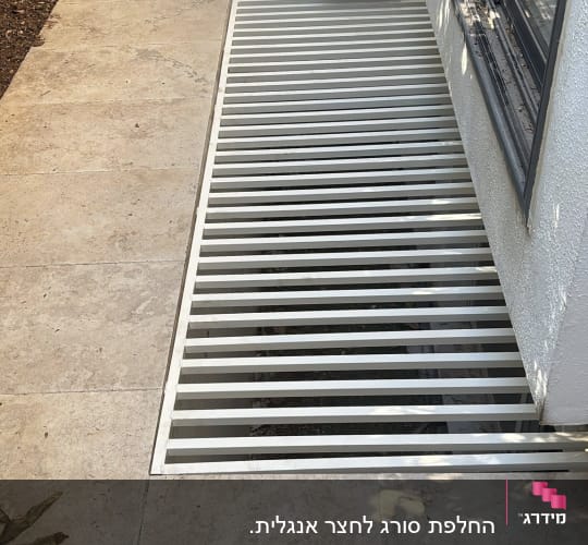 סורג מתכת מותקן על רצפת מרפסת ליד מזגן